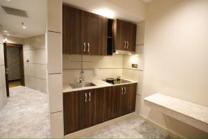 a kitchen with wooden cabinets and a sink at Zamzam Hotel 2 in An Najaf