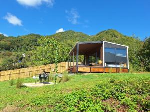 a glass house in a field with mountains in the background at 17HILLS Cottage in Acharistsqali