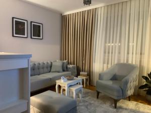 a living room with a couch and a chair at Urban Apartman-privatan parking- in Kraljevo