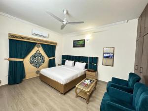 a hotel room with a bed and a blue couch at Dream Inn Guest House Islamabad in Islamabad