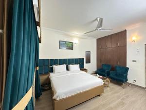 a hotel room with a bed and a blue curtain at Dream Inn Guest House Islamabad in Islamabad