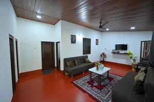 a living room with a couch and a table at Swarna Green Valley Resort in Perdūru