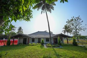 a house with a palm tree at Swarna Green Valley Resort in Perdūru +5 photos