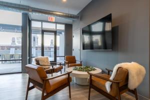 a living room with chairs and a table and a exit sign at Loop 1BR w Deck Gym WD nr W Loop the L CHI-220 in Chicago