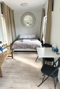 利斯戈Micro Mansion with big deck and views in Lovely Lithglow的一间卧室，配有一张床、一张桌子和几把椅子