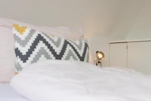 a bedroom with a white bed and a lamp at Meer-Lust-Sylt Sonnenhäuschen in Westerland