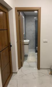 a bathroom with a toilet and a sink and a door at Urban Apartman-privatan parking- in Kraljevo