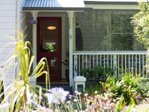 a front porch with a red door and flowers at Barbara's Guesthouse in Byron Bay