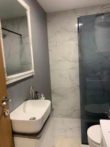 a bathroom with a white sink and a shower at Urban Apartman-privatan parking- in Kraljevo