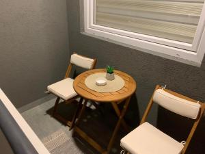 a small table with two chairs and a plant on it at Urban Apartman-privatan parking- in Kraljevo