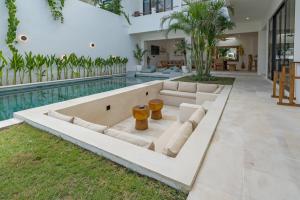 an open living room with a pool and a couch at Villa Kleoa - Luxury 4 Bedrooms Villa Walking Distance to Seseh Beach in Canggu