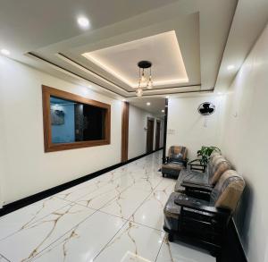 a living room with two leather couches and a television at Shanthi Tourist Home in Pathanāmthitta