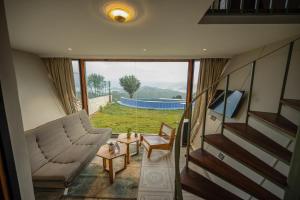 a living room with a couch and a tv at Himadvaya- The Himalayan Prism in Almora