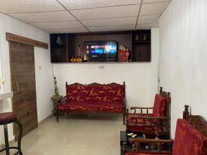 a living room with a red couch and a tv at Suite De Ana in Guayaquil