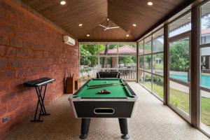 a pool table in a room with a brick wall at SaffronStays Euphoria Shores in Kīhīm