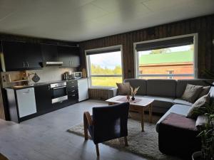 a living room with a couch and a table at Lillehytta årøybuktneset in Elvejord +13 photos