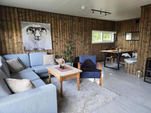 a living room with a couch and a cow on the wall at Lillehytta årøybuktneset in Elvejord