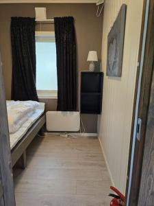 a small bedroom with a bed and a window at Lillehytta årøybuktneset in Elvejord
