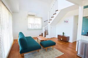 a living room with a blue couch and a table at jfハウス - カフェ併設の一棟貸切で楽しむプライベートステイ - サーフポイントまで徒歩5分 in Ichinomiya