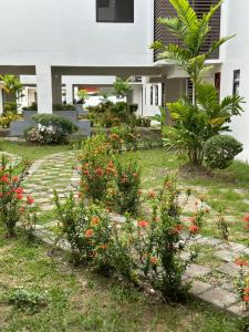 een tuin met bloemen voor een huis bij Cozy Condo Almond drive 1BR Talisay SRP w pool in Tangke