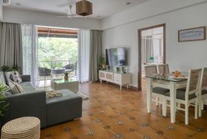 a living room with a couch and a table at Radiant 1BHK Apartment by tisyastays in Candolim