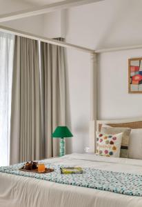 a bedroom with a bed with a tray of food on it at Radiant 1BHK Apartment by tisyastays in Candolim +3 photos