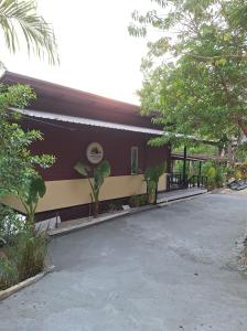 a building with a parking lot in front of it at บ้านริมชล บ้านสวนสราญชล in Ban Khlong Ha Nua +1 photo