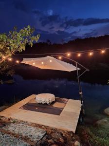 a boat with an umbrella on the water at night at บ้านริมชล บ้านสวนสราญชล in Ban Khlong Ha Nua