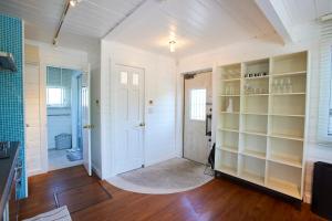 a room with white walls and a door with shelves at jfハウス - カフェ併設の一棟貸切で楽しむプライベートステイ - サーフポイントまで徒歩5分 in Ichinomiya +77 photos