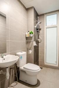 Un baño con inodoro, lavabo y ventana. en Spacious 3BR Condo in Residensi Suasana Damai, en Petaling Jaya