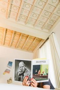 una donna che tiene in mano un libro con un poster di un uomo di Parisii Bocca di Leone 88 a Roma Altre 41 foto