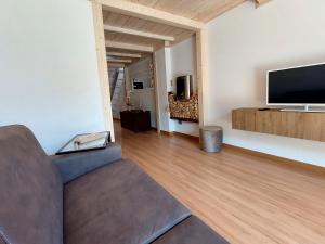 a living room with a couch and a flat screen tv at Loft Open Space Adele -Tirano Centro Storico in Tirano