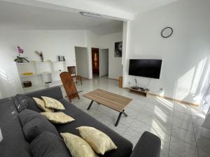 una sala de estar con un sofá y una mesa en Casa Valencia, proche de toutes commodités, en Saint-Pierre