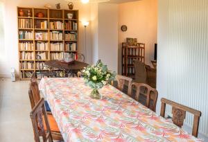 a dining room table with a vase of flowers on it at RÉF 407 - LARMOR PLAGE Maison de famille pleine vue mer in Larmor-Plage