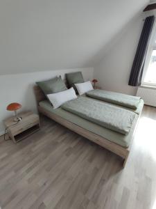 a bed in a room with a wooden floor at Alte Schule in Altratjensdorf