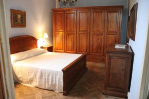 a bedroom with a bed and a wooden cabinet at Appartamento in zona storica in Battaglia Terme