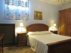 a bedroom with a bed and two night stands and two lamps at Appartamento in zona storica in Battaglia Terme
