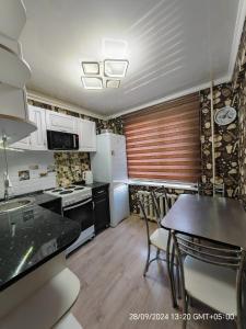 バルハシにあるУютная квартираのキッチン(テーブル、椅子付)