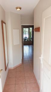 a room with a hallway with a tile floor at Maison, proche parking, piscine chauffée, en résidence, 4 ou 5 pers, RDC, lac, nature et pêche in Monflanquin +26 photos