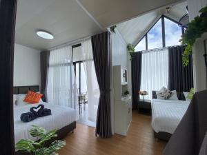 a bedroom with two beds and a large window at เมฆสวรรค์ ภูทับเบิก 2 in Ban Maeo Thap Boek