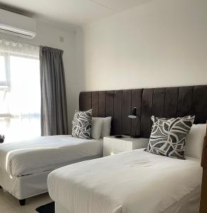 ein Schlafzimmer mit zwei Betten und einem großen Fenster in der Unterkunft Grey Net in Palatswe