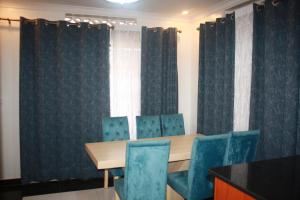 a conference room with a table and blue chairs at VENUS APARTMENT Kigali in Kigali