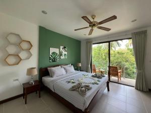 a bedroom with a large bed with a ceiling fan at Woodlawn Villas Resort in Koh Tao +80 photos