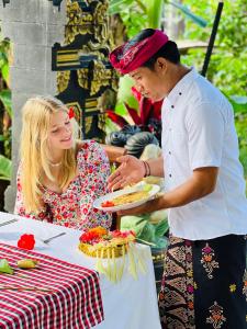 a man and a woman holding a plate of food at D'karang Eco Lodge in Undisan