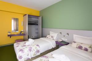 two beds in a room with yellow and green walls at Mini Harem Hotel in Istanbul