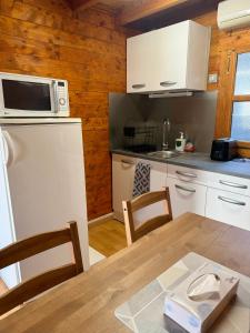 a kitchen with a table and a white refrigerator at Cozy cottage Paris Suburb! in Bobigny +15 photos