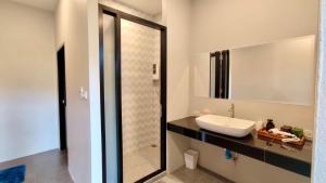 a bathroom with a sink and a mirror at Mon Tresor Garden มง เทร ซอ in Amphoe Sawang Daen Din +7 photos
