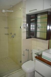 a bathroom with a toilet and a glass shower at Apto 206 Frente Mar Elegance Flat in Natal