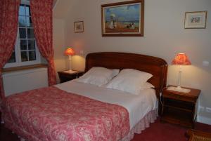 a bedroom with a bed and two lamps on tables at Hostellerie de la Motte jean in Saint-Coulomb