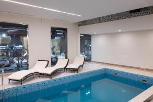 a swimming pool with chairs and a screen in a building at Vender Hotel in Taif
